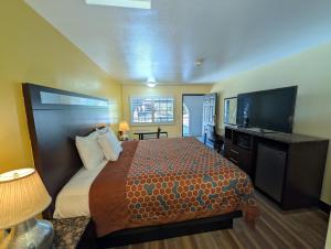 a hotel room with a bed and a flat screen tv at Crossroads Inn - Downtown Sacramento in Sacramento