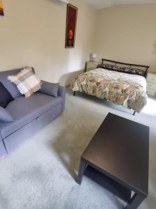 a living room with a bed and a couch at Garden Dreams bungalow in Blackburn