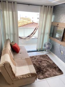 salon z kanapą i dużym oknem w obiekcie Caribessa é Aqui !!! w mieście João Pessoa