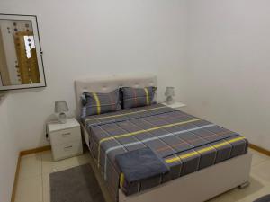 ein kleines Schlafzimmer mit einem Bett und einem Spiegel in der Unterkunft vitoria in Praia + 15 Fotos