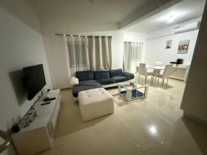 ein Wohnzimmer mit einem blauen Sofa und einem Tisch in der Unterkunft vitoria in Praia