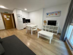 Il comprend un salon avec une table blanche et une cuisine. dans l'établissement SF40 Vut, à Lugo