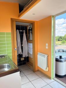 杜尔涅Maison de village , terrasse et spa的厨房设有橙色墙壁和水槽