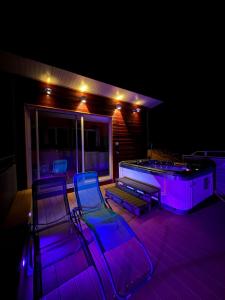 a group of chairs sitting on a deck at night at Maison de village , terrasse et spa in Dourgne