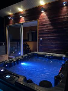 杜尔涅Maison de village , terrasse et spa的窗户客房内的大蓝色浴缸