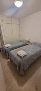 two beds in a room with towels on them at Departamento Capital San Juan in San Juan