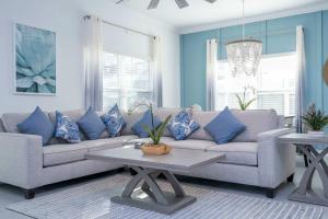 a living room with a couch with blue pillows at NEW to Market 5 Bed - Storey Lake Retreat in Kissimmee +87 photos
