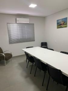 a conference room with a white table and chairs at HOTEL ROYAL AMAMBAI in Amambaí