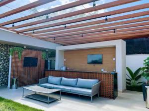 a living room with a blue couch on a patio at SouMaisTemporada RJ in Niterói