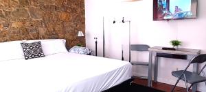 a bedroom with a bed and a stone wall at Estudio Casco Histórico II & Parking in Avilés