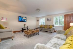 a living room with two couches and a coffee table at Helyg in Penmaen-mawr