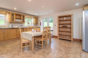 a kitchen with a table and chairs and a refrigerator at Helyg in Penmaen-mawr +21 photos