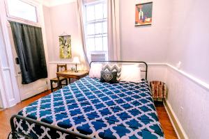 a bedroom with a bed with a blue and white comforter at Kerlerec Victorian Cottage - Steps to French Qtr. in New Orleans