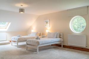 two beds in a room with a window at Helyg in Penmaen-mawr