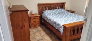 a bedroom with a wooden bed and a wooden dresser at River Cottage at Mannum in Mannum