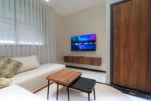 a living room with a couch and a tv on a wall at Welcomly 10 - Luxury apartment in Tangier in Tangier