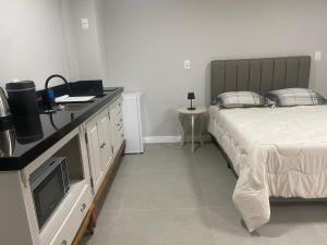 a bedroom with a bed and a dresser with a television at LOFTS Vila Germânica in Blumenau