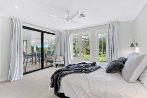 ein weißes Schlafzimmer mit einem Bett und einem Esszimmer in der Unterkunft Whitepepper Cottage in Pokolbin + 17 Fotos