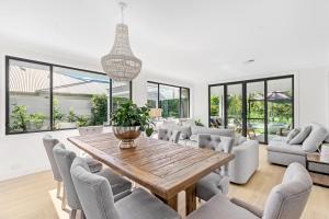 ein Wohnzimmer mit einem Holztisch und Stühlen in der Unterkunft Whitepepper Cottage in Pokolbin