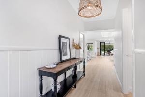 einen Flur mit einem Konsole-Tisch in einem Haus in der Unterkunft Whitepepper Cottage in Pokolbin
