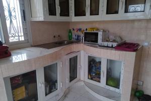 SangalkamにあるVILLA 379 Cité Les Manguiers de BAMBILORのキッチン(白いキャビネット、電子レンジ付きのカウンター付)