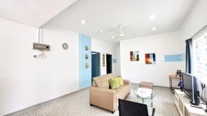 ein Wohnzimmer mit Sofa und Fernseher in der Unterkunft MediSehat Budget Stay, Near Mount Miriam Cancer Hospital in Tanjung Bungah