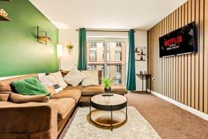 a living room with a couch and a table at Stylish Leeds City Centre 2BR - Free Parking - 2 Mins to First Direct Arena in Central Station
