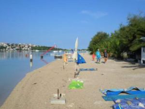 un gruppo di persone su una spiaggia vicino all'acqua di Apartments Miki Rogoznica - Classic Two Bedroom Apartment with Terrace a Podglavica Altre 4 foto