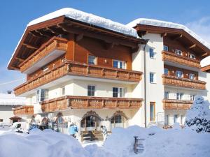 Un gran edificio con nieve delante. en Peaceful Balcony Retreat in Wildschönau, cleaning included, en Niederau