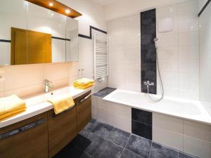 Un baño con bañera, lavabo y ducha. en Spacious Apartment in Kitzbühel Alps, cleaning included, en Niederau 12 fotos más