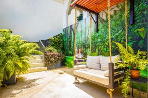 a porch with a swing with plants and a mural at Patio Elba Boutique Hotel in San Juan +84 photos