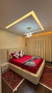 1 dormitorio con 1 cama grande de color rojo y lámpara de araña en Luxury apartment in Essaouira, en Essaouira