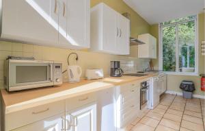 a kitchen with white cabinets and a microwave at 5 Bedroom Stunning Home In Quiestede in Quiestède