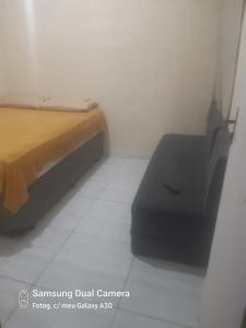 a bedroom with a bed and a chair in a room at Casa sobrado in Arraial do Cabo +4 photos