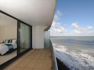 a bedroom with a bed and a view of the ocean at Tidal Bay in Westward Ho +4 photos