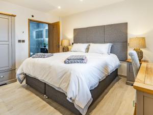 ein Schlafzimmer mit einem großen Bett mit großem Kopfteil in der Unterkunft Bay Tree Cottage - Uk35891 in Ludchurch + 12 Fotos