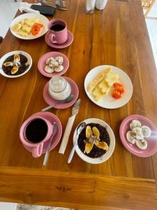 a wooden table with plates of food and cups of coffee at Arta Dani villas in Sidemen
