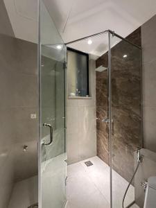 een douche met een glazen deur in een badkamer bij Executive Prestige Hotel Apartments Facing Centautus - Elysium Tower Islamabad in Islamabad