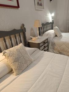a bedroom with two beds and a table with a lamp at CASA RURAL ALEGRÍA in Caudete de las Fuentes