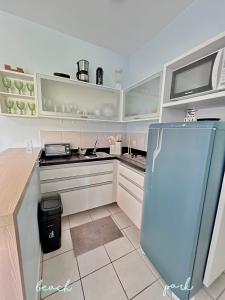 a kitchen with white cabinets and a blue refrigerator at Apartamento Particular à Beira do Mar e pé na areia em Acqua Resort Beach Park in Aquiraz +97 photos