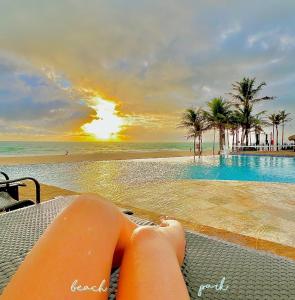 a woman laying on a chair next to a swimming pool at Apartamento Particular à Beira do Mar e pé na areia em Acqua Resort Beach Park in Aquiraz