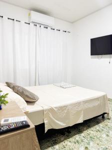 a white room with a bed and a tv at Apartamento comodo y bonito cerca a Unicentro in Yopal