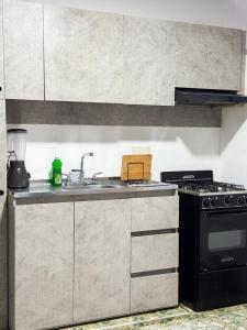 a kitchen with a sink and a stove at Apartamento comodo y bonito cerca a Unicentro in Yopal