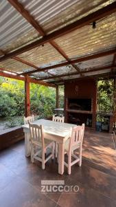 a table and chairs on a patio with awning at Casa moderna en Valeria del Mar in Valeria del Mar