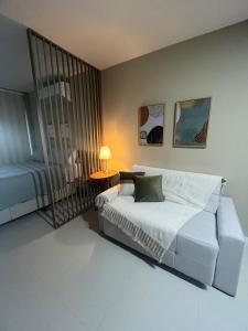 SkyLux Studio Novo e Confortável no Centro في ريو دي جانيرو: غرفة نوم بها سرير وطاولة ومصباح