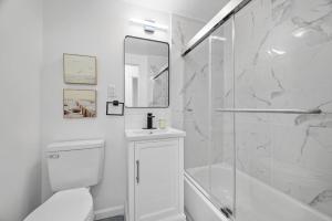 a white bathroom with a toilet and a shower at Pittsburgh Shadyside 1D Stylish and Cozy Private Bedroom with Shared Bathroom in Pittsburgh