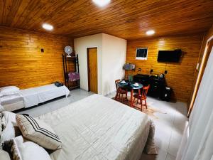 a bedroom with a large bed and a table in it at Cabanas Coimbra in Urubici +9 photos