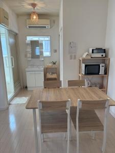 a dining room with a wooden table and chairs at ゲストハウスharu in Shingū +12 photos