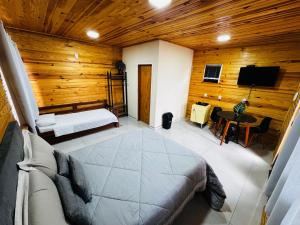 a bedroom with a bed and a tv in a room at Cabanas Coimbra in Urubici