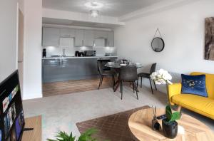 a living room with a yellow couch and a kitchen at Modern Downtown Gem- Brand New Apartments on Cannon St in Preston